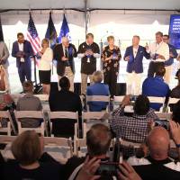 Group on stage holding footballs at the Jamie Hosford Football Center dedication.
